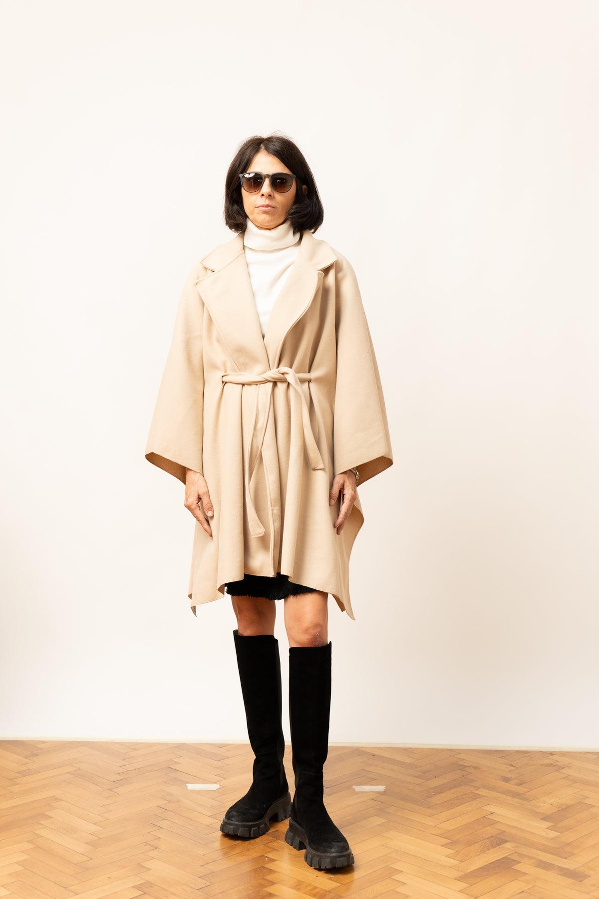 Pelerină bej elegantă cu cordon și revere largi, privire frontală simplă.