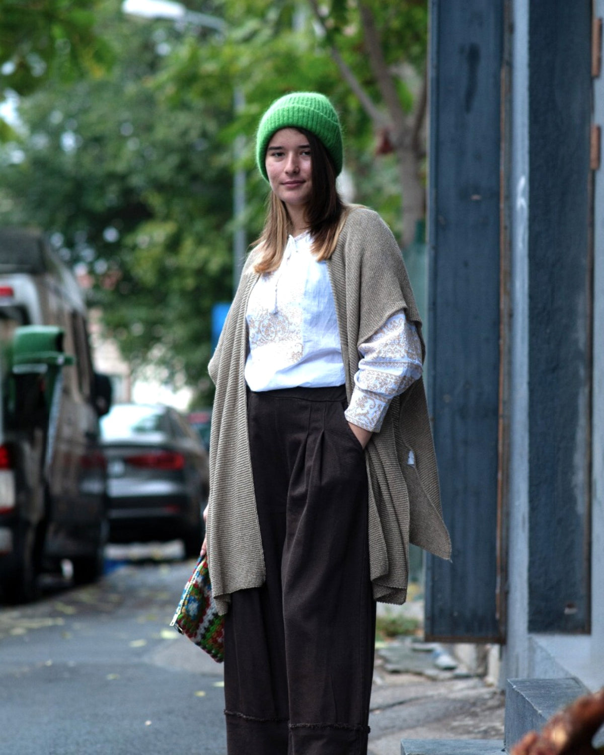 Pelerină tricotată bej, cu textură fină și guler moale, expusă pe manechin.