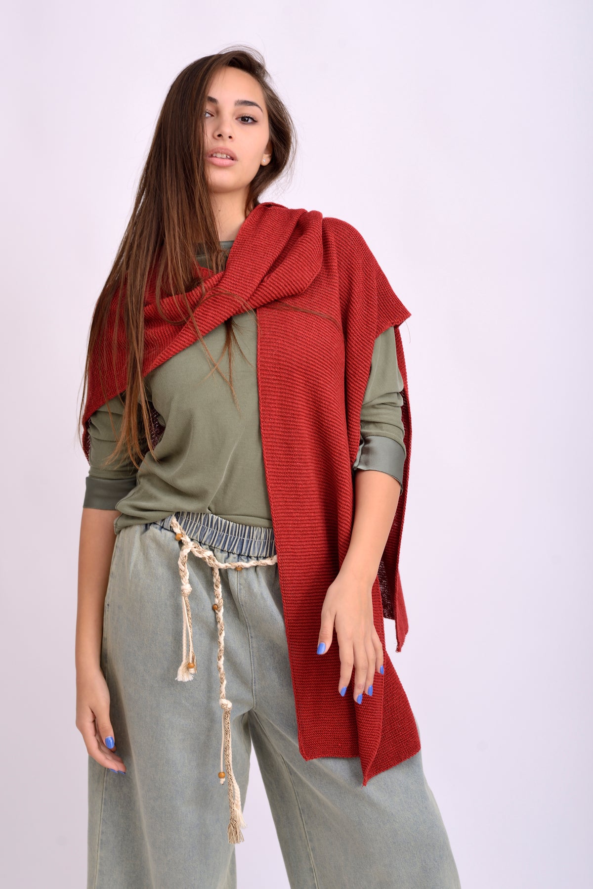 Detaliu textură și croială a pelerinei tricotate roșii, material moale și vaporos.