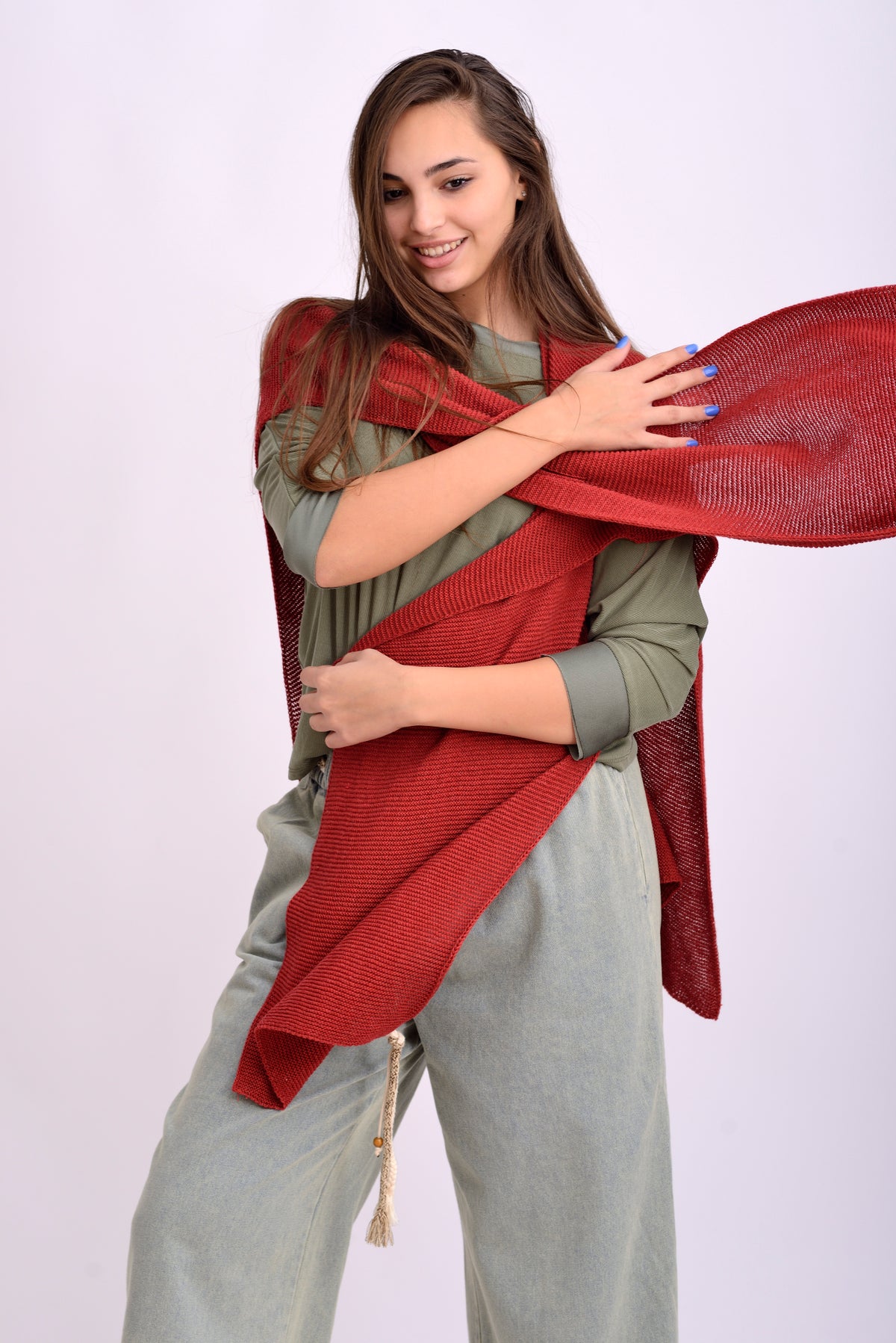 Detaliu textură și croială a pelerinei tricotate roșii, material moale și vaporos.