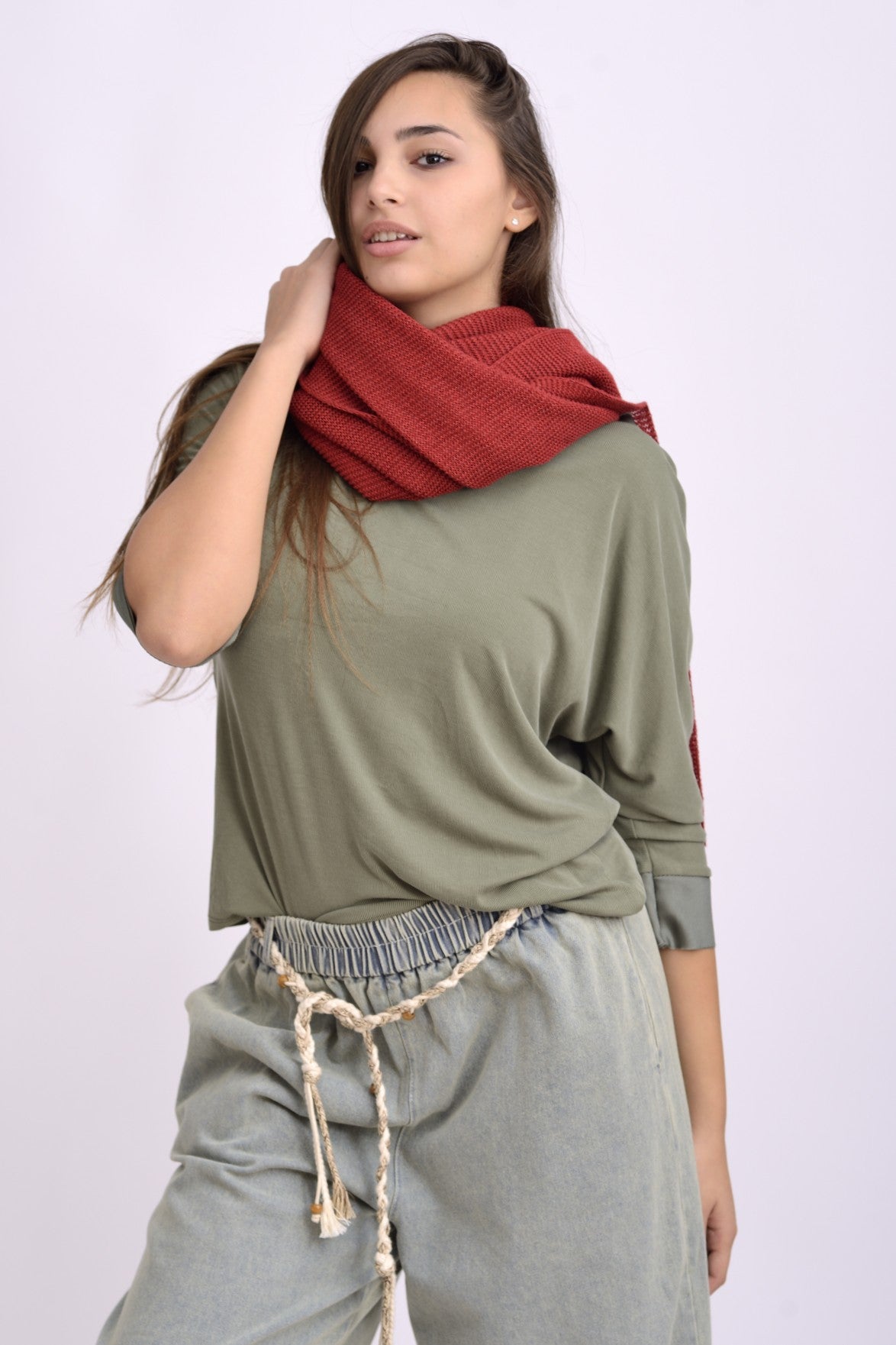 Detaliu textură și croială a pelerinei tricotate roșii, material moale și vaporos.