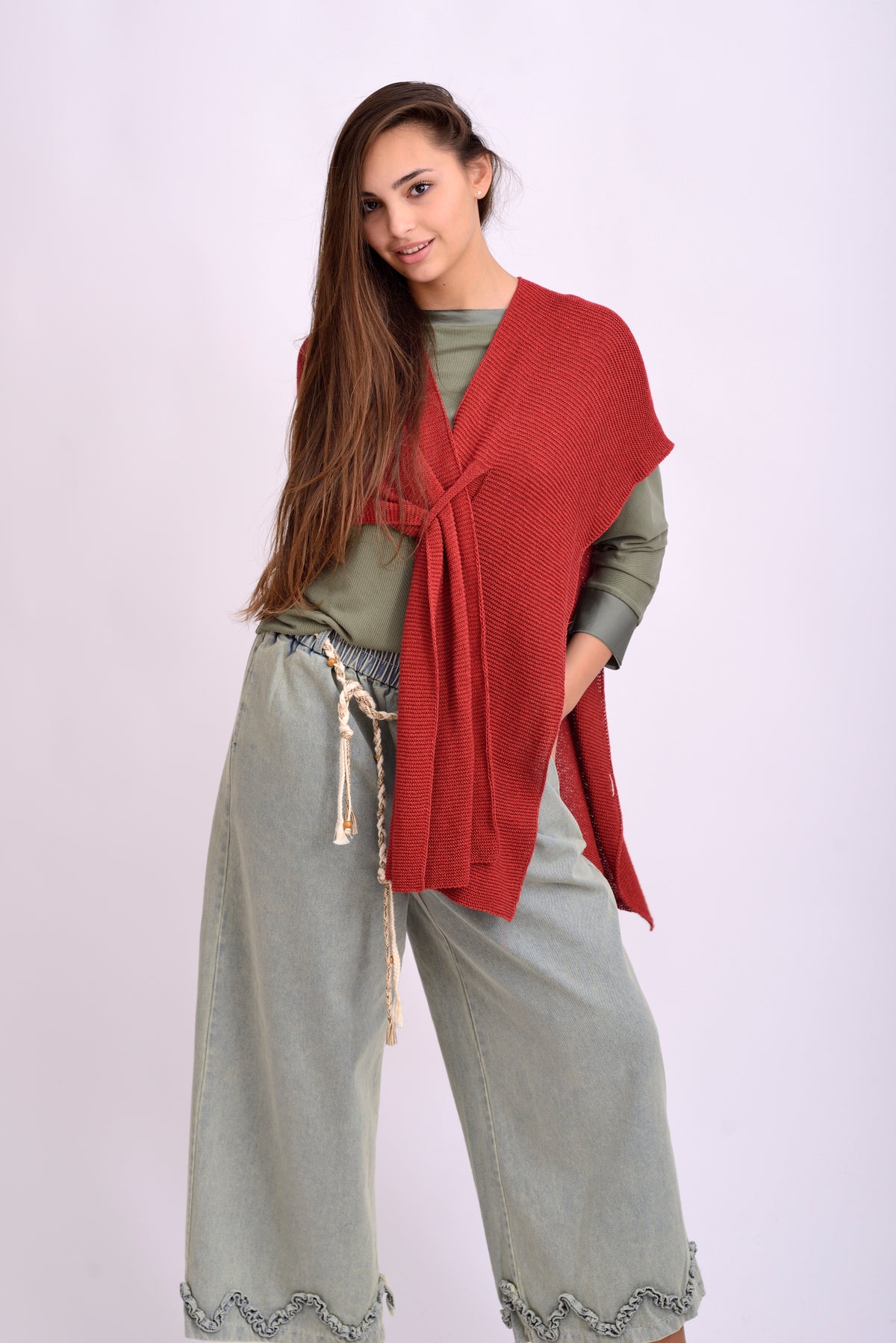 edere laterală a pelerinei tricotate roșii, cu design amplu și croială asimetrică.