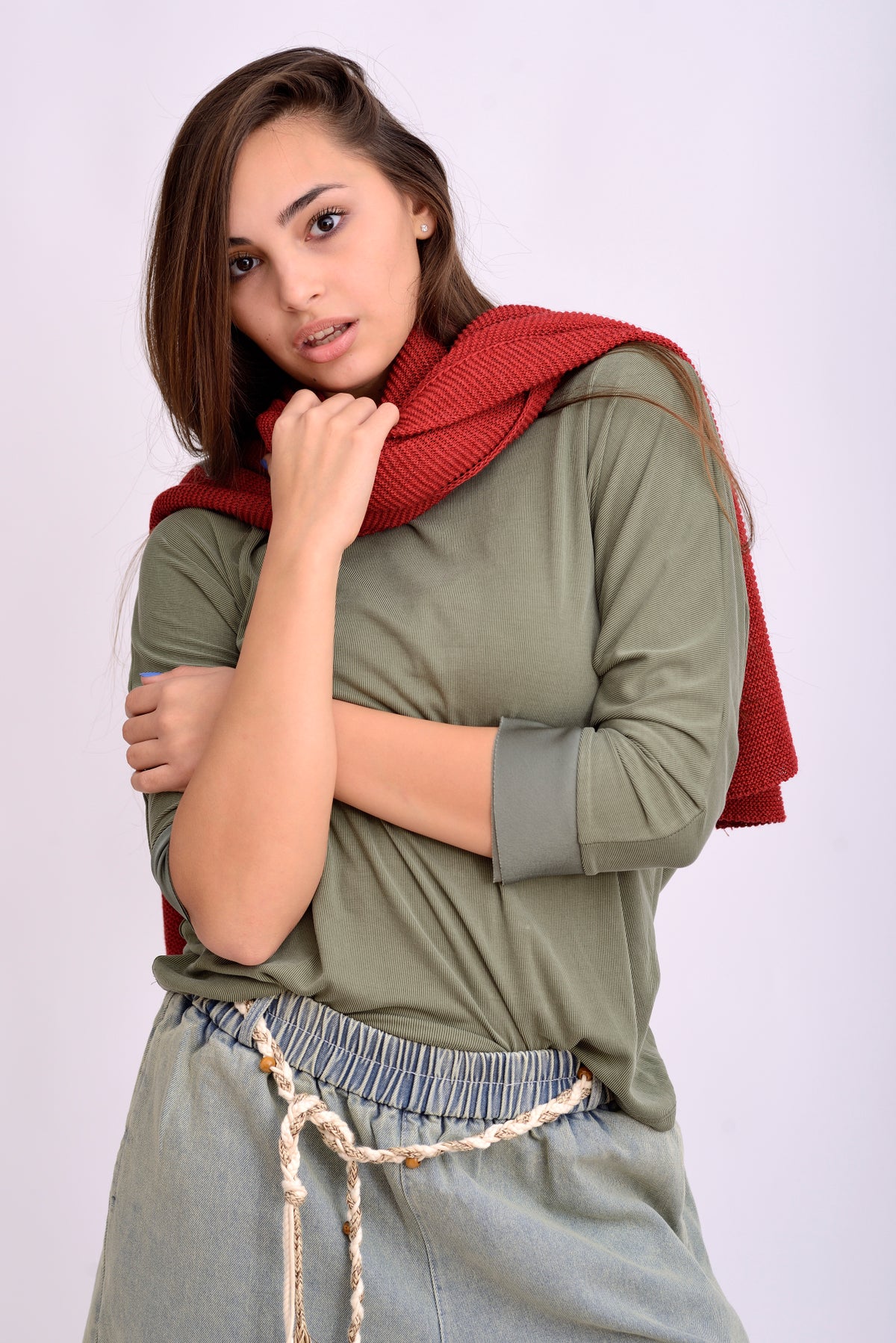 Detaliu textură și croială a pelerinei tricotate roșii, material moale și vaporos.