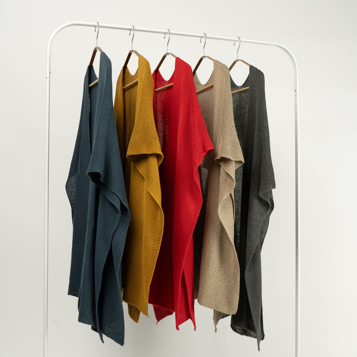 Set de pelerine tricotate în diverse culori – gri, bej, roșu, galben muștar și negru.