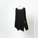 Pulover negru tricotat cu decolteu în V și tăieturi laterale asimetrice.