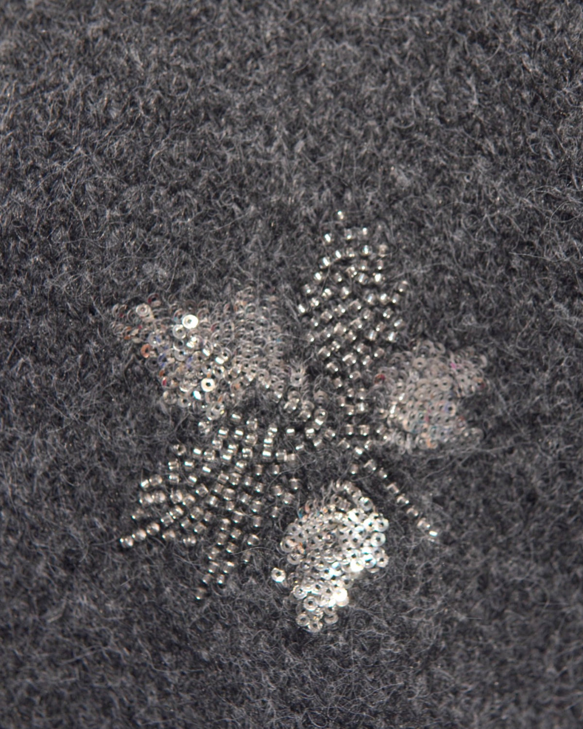 Paiete în formă de frunze aplicate pe materialul moale al puloverului