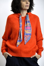 Pulover tricotat portocaliu cu guler rotund, croială lejeră și finisaje rib la bază și manșete.