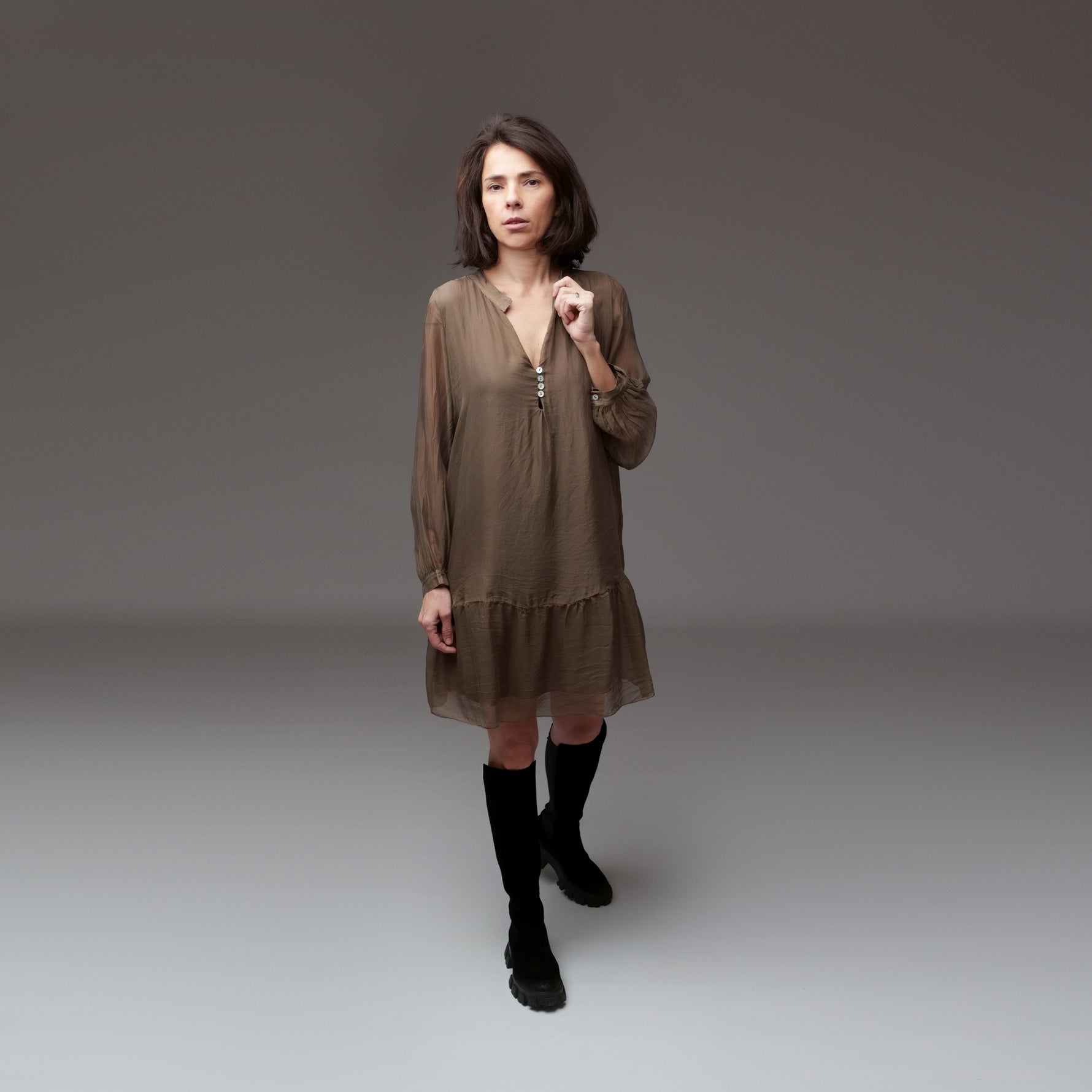 Rochie maro din mătase purtată de model, cu mâneci transparente și bocanci negri, într-un look urban boem.