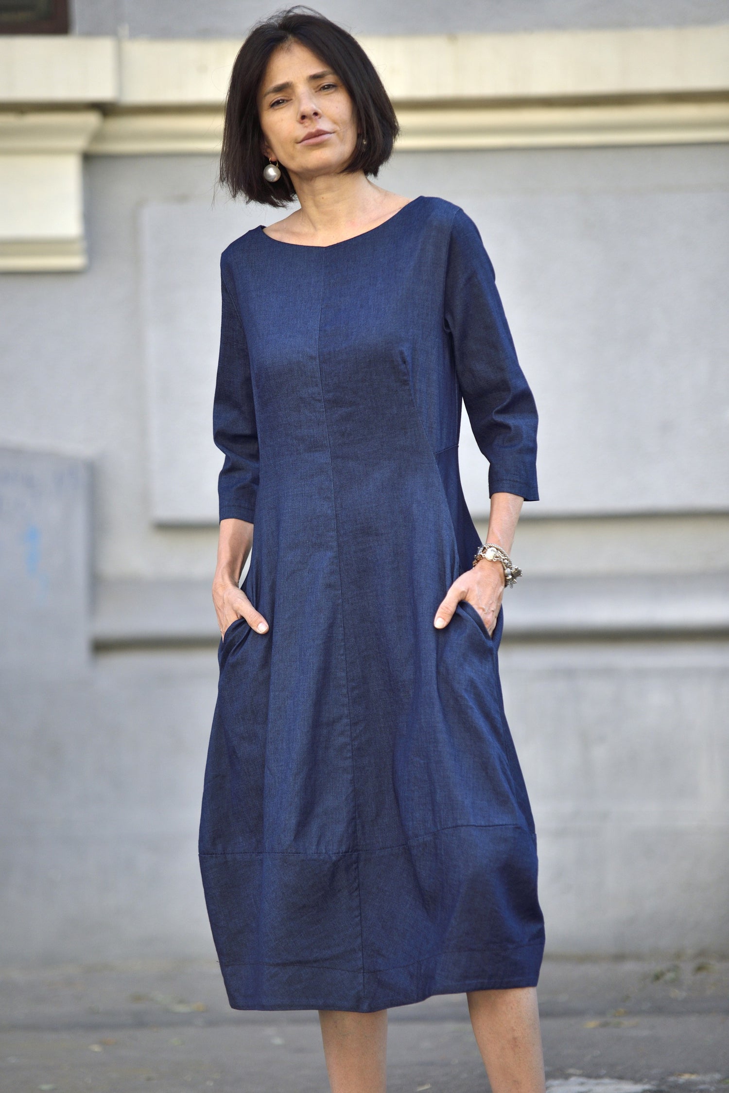 Rochie midi din denim bleumarin cu mâneci trei sferturi, buzunare laterale și croială lejeră, văzută din față