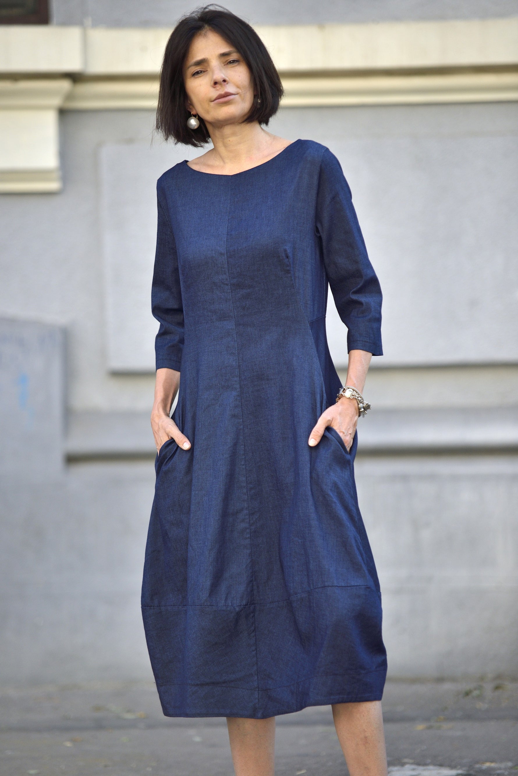 Rochie midi din denim bleumarin cu mâneci trei sferturi, buzunare laterale și croială lejeră, văzută din față
