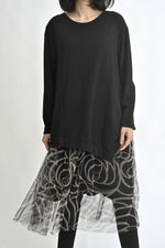 Detaliu al rochiei negre cu strat de tul imprimat zebra, evidențiind suprapunerea materialelor.