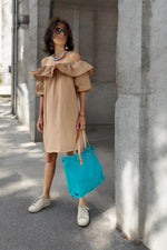 Rochie scurtă bej din bumbac, cu volan și siluetă dreaptă, purtată la ținută de zi.