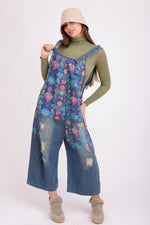 Salopetă denim cu bretele și imprimeu floral, vedere laterală pe model.