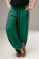 Detaliu al șalvarilor verzi din bumbac, cu talie lată elastică și prindere elastică jos, în stil relaxat și fluid.