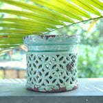 Suport de lumânare din ceramică turcoaz, model perforat tip dantelă, vedere frontală pe fundal alb.