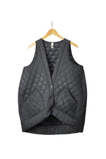Vestă matlasată neagră, fără mâneci, cu nasturi și buzunare mari, expusă pe umeraș.