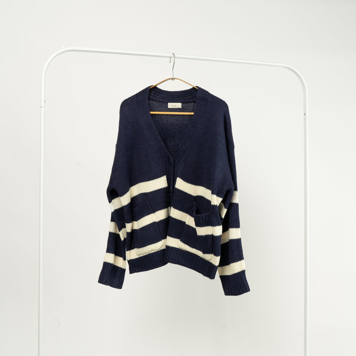 Cardigan navy tricotat, cu dungi albe, nasturi și buzunare, vedere din față.