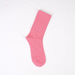 Șosetă roz mediu, fără cusături vizibile, aspect elegant.
