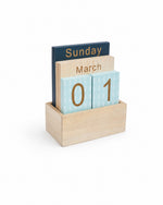 Calendar perpetuu din lemn cu cifre aurii pe plăcuțe bleu cu model de brăduți, vedere din unghi - All Above Boutique