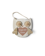 Ornament din lemn în formă de bufniță, cu mesajul „Hugs & Kisses”.
