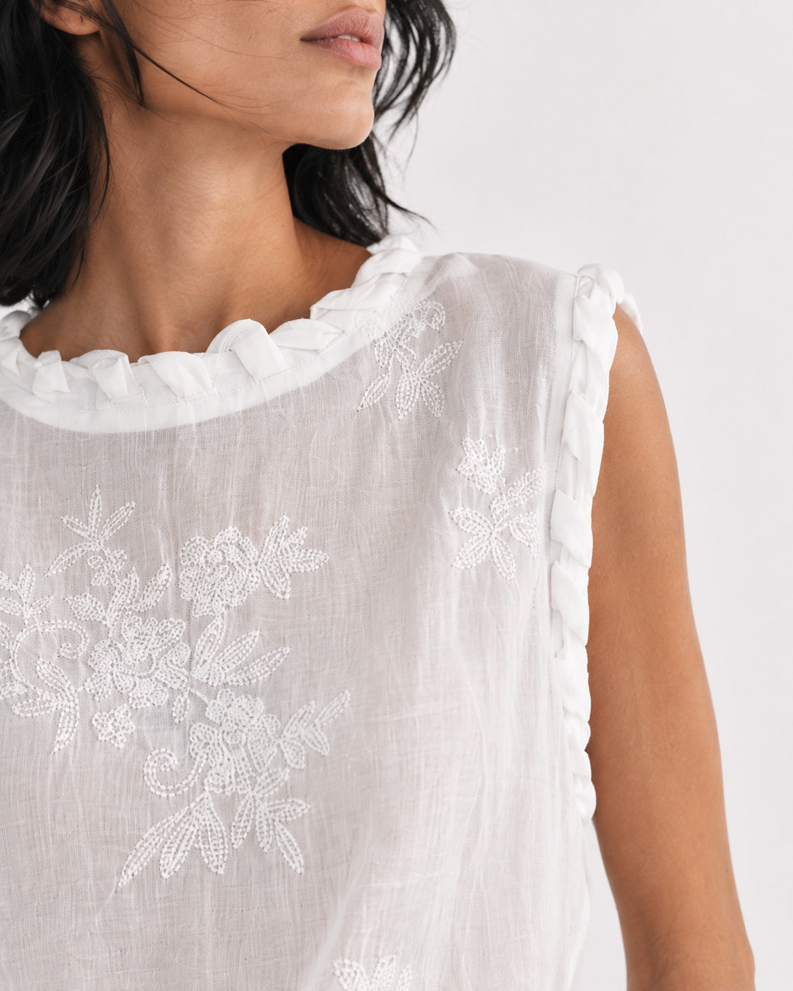 Top cu broderie florală și finisaje împletite, în nuanța alb, detaliu al broderiei florale și al finisajelor împletite.