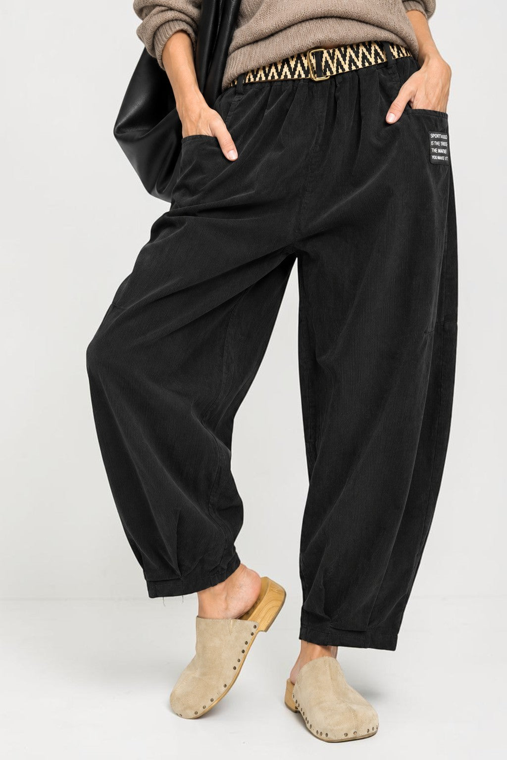 Pantaloni reiați lejeri cu talie elastică, în nuanța negru, vedere frontală.