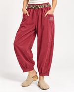 Pantaloni reiați lejeri cu talie elastică, în nuanța roșu, vedere frontală.