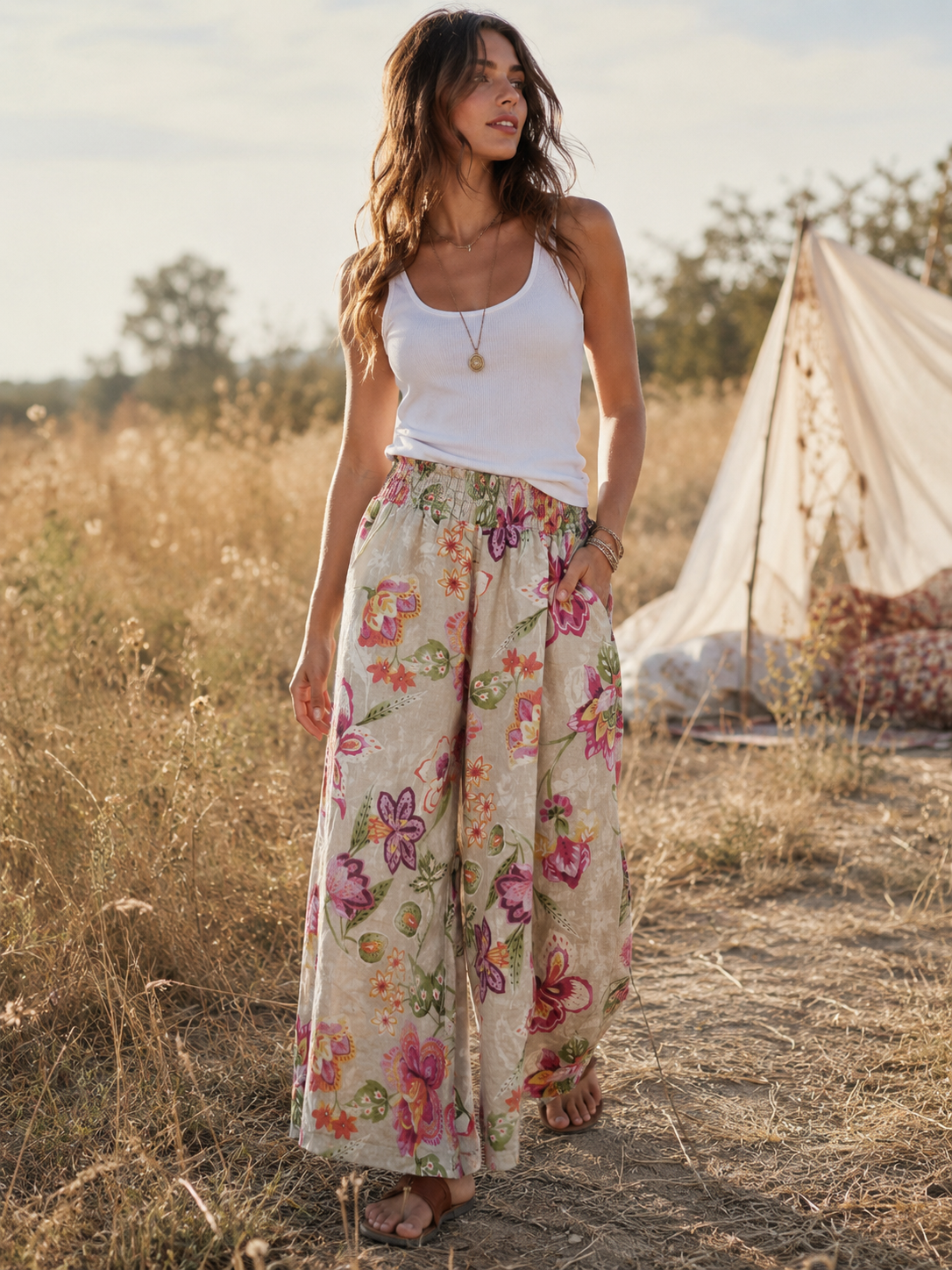 Pantaloni lungi evazați din in cu print floral roz-crem, purtați cu top alb, fundal boem câmp, All Above Boutique