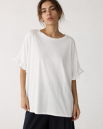 Tricou oversize lung din bumbac cu volane la mâneci, în nuanța alb, vedere frontală.