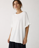 Tricou oversize lung din bumbac cu volane la mâneci, purtat de model, vedere de ansamblu.