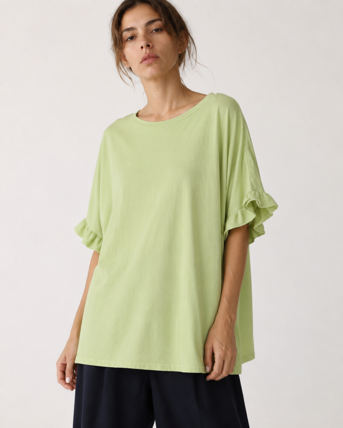 Tricou oversize lung din bumbac cu volane la mâneci, în nuanța verde fistic, vedere frontală.
