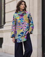 Jachetă structurată midi cu imprimeu multicolor viu, purtată într-o ținută street style.