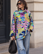 Jachetă structurată midi cu imprimeu multicolor viu, în nuanța verde pal, purtată într-o ținută street style.
