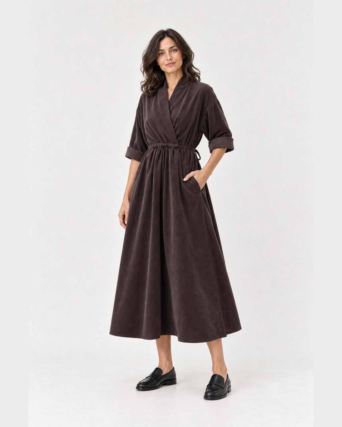 Rochie midi maro din catifea reiată, cu guler șal și șnur în talie, purtată cu mâna în buzunar - All Above Boutique