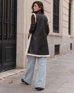 Vestă reversibilă din piele ecologică neagră cu margini de blăniță, văzută din spate, All Above Boutique