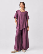 Compleu cu aspect mătăsos, cu top larg și pantalon despicat, în nuanța violet, vedere frontală.