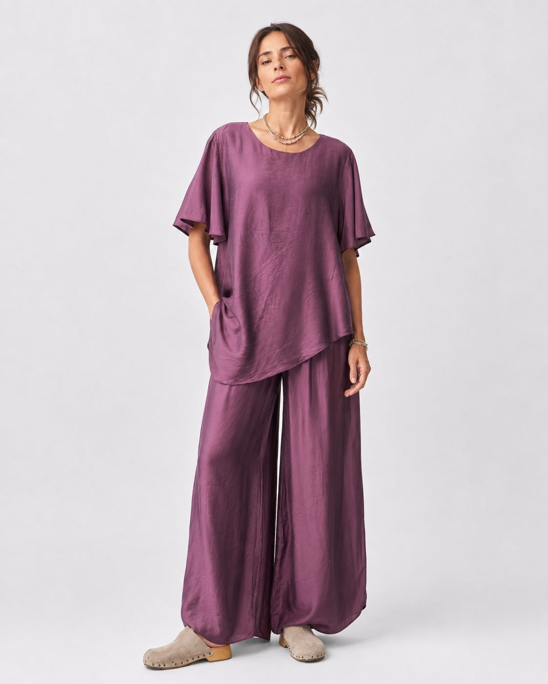 Compleu cu aspect mătăsos, cu top larg și pantalon despicat, în nuanța violet, vedere frontală.