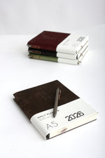 Set agendă 2026 cu copertă din catifea maro și pix elegant metalic.