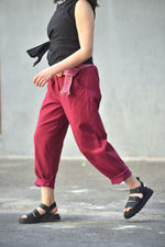 Pantaloni conici din viscoză cu centură etnică surprinși în mișcare, croială lejeră.