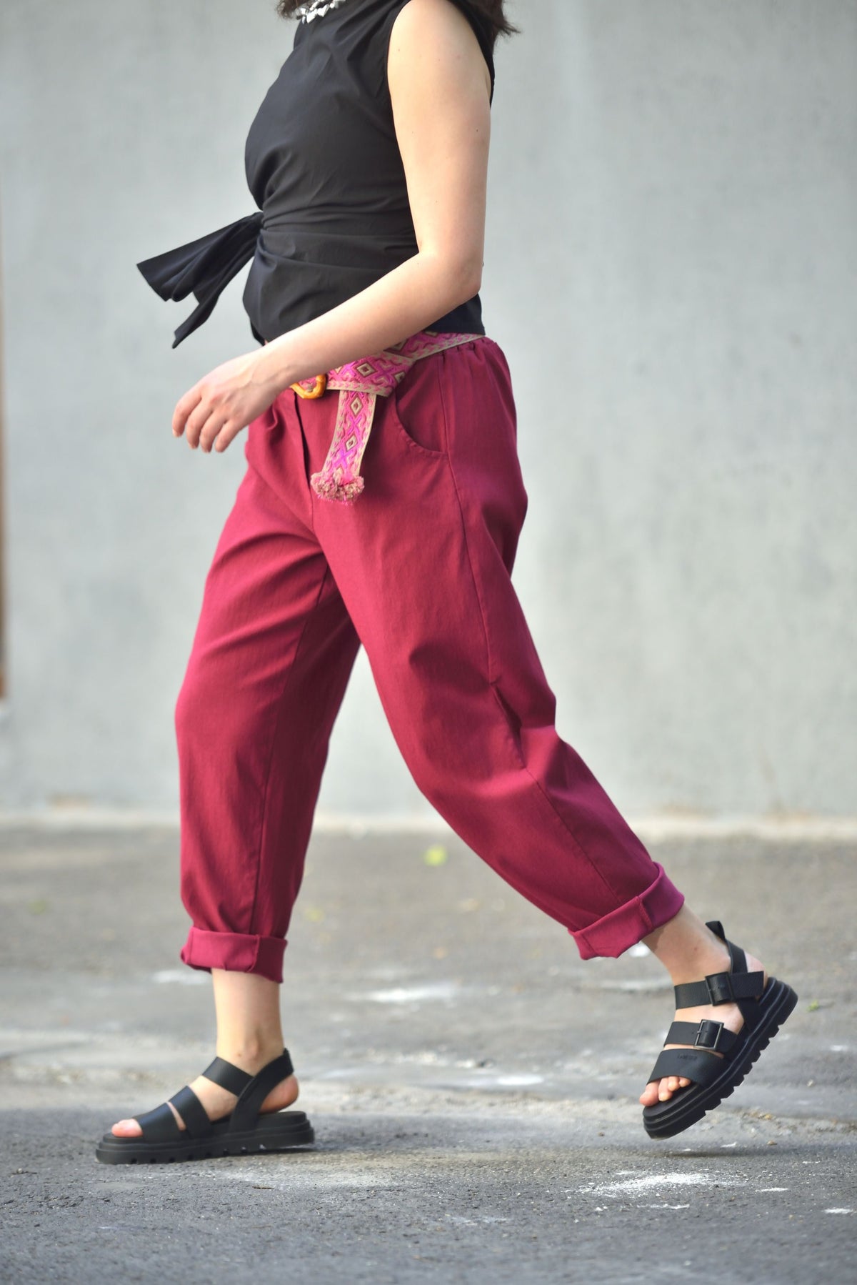 Pantaloni conici din viscoză cu centură etnică surprinși în mișcare, croială lejeră.