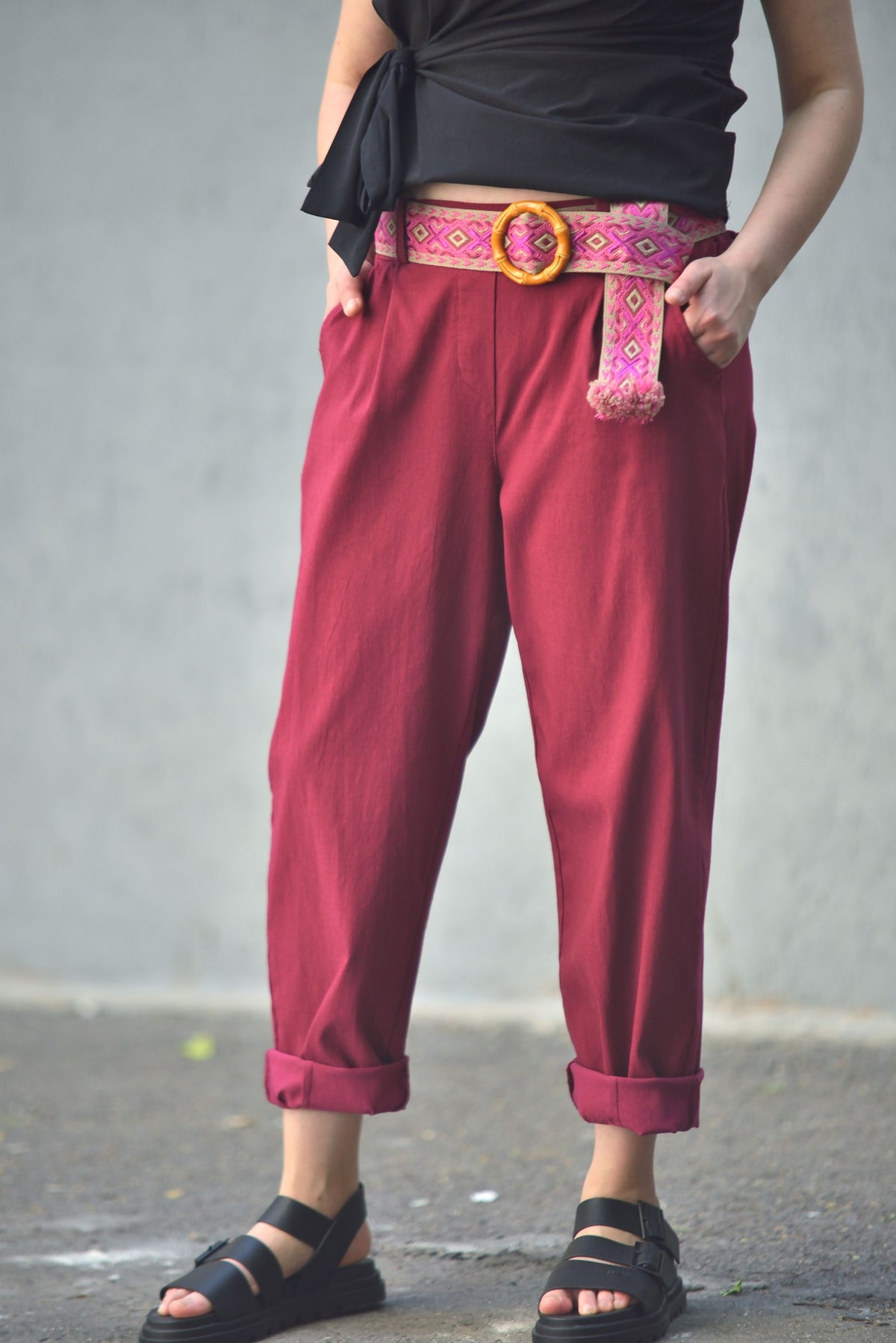 Pantaloni conici din viscoză cu centură etnică colorată, în nuanța roșu închis, vedere frontală.
