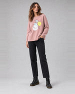 Bluză oversize din bumbac cu imprimeu chipuri, în nuanța roz deschis, purtată pe model, All Above Boutique