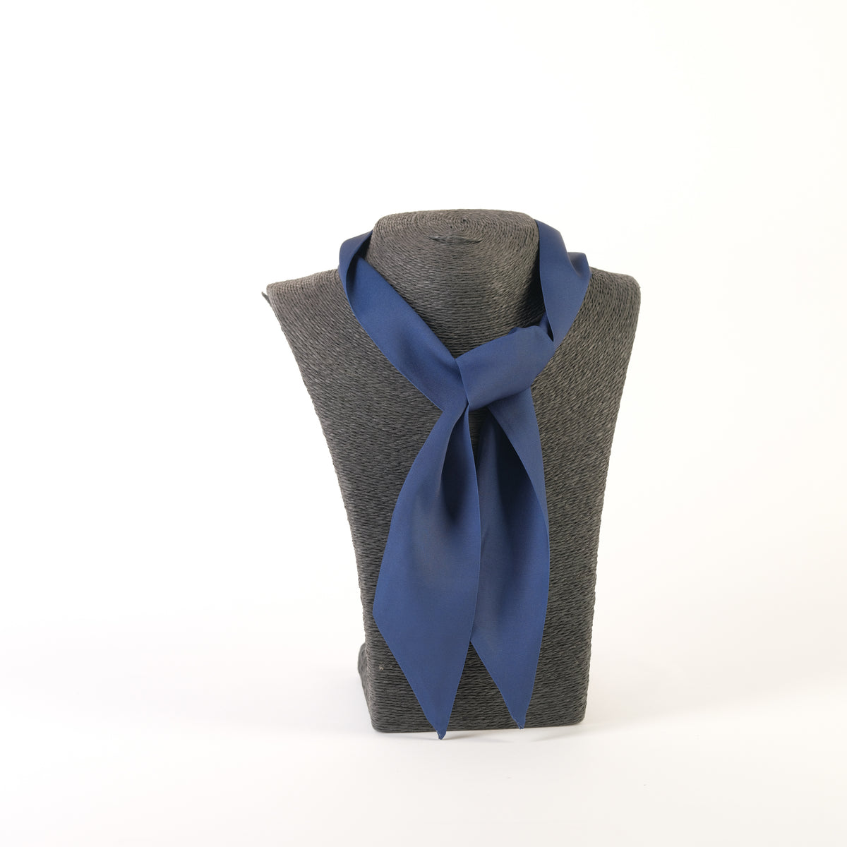 Eșarfă satinată expusă pe un suport gri, versatilă pentru a fi purtată ca bentiță, cravată sau accesoriu pentru geantă.