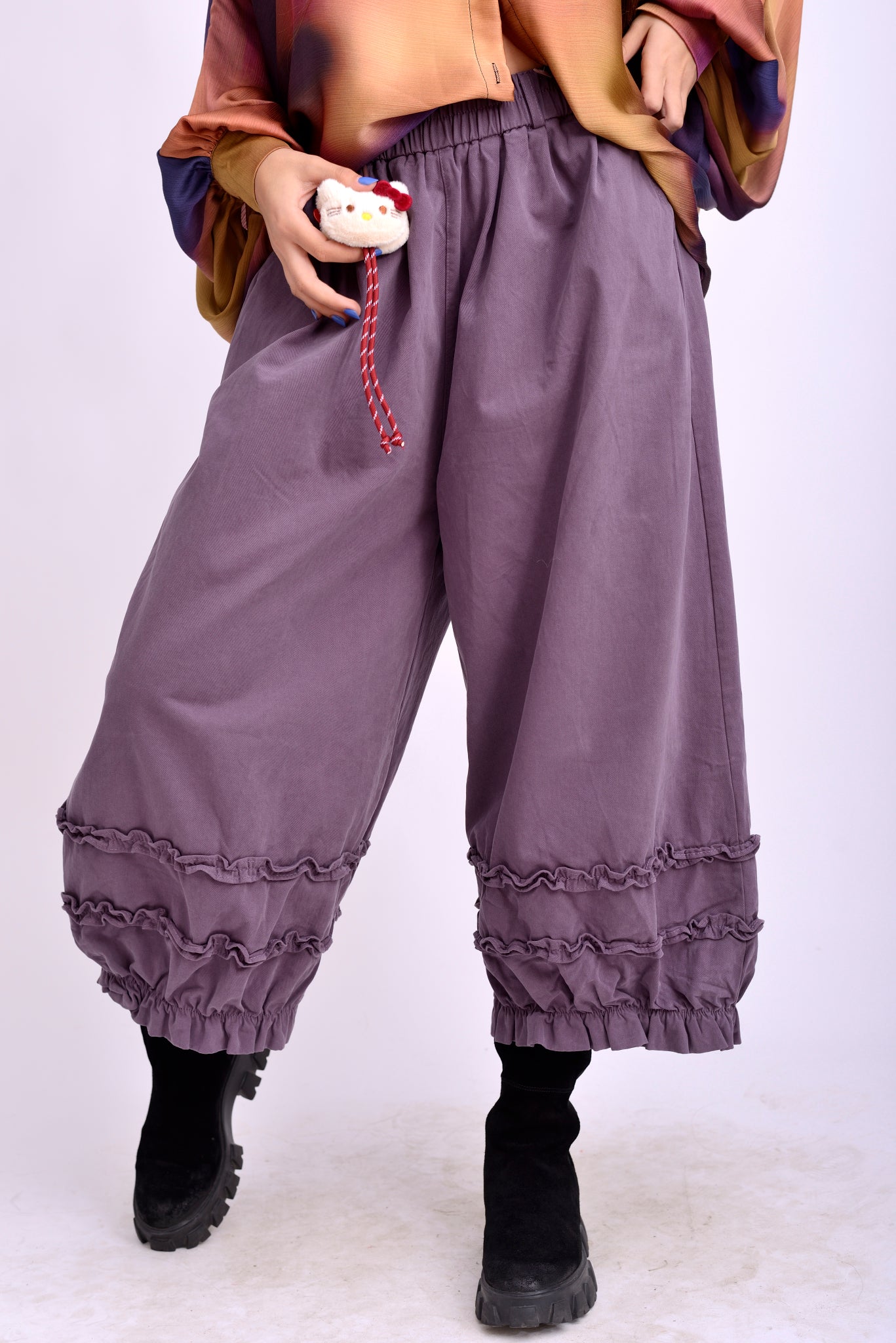 Vedere din spate a pantalonilor colorați cu volănașe la tiv, din bumbac natural.
