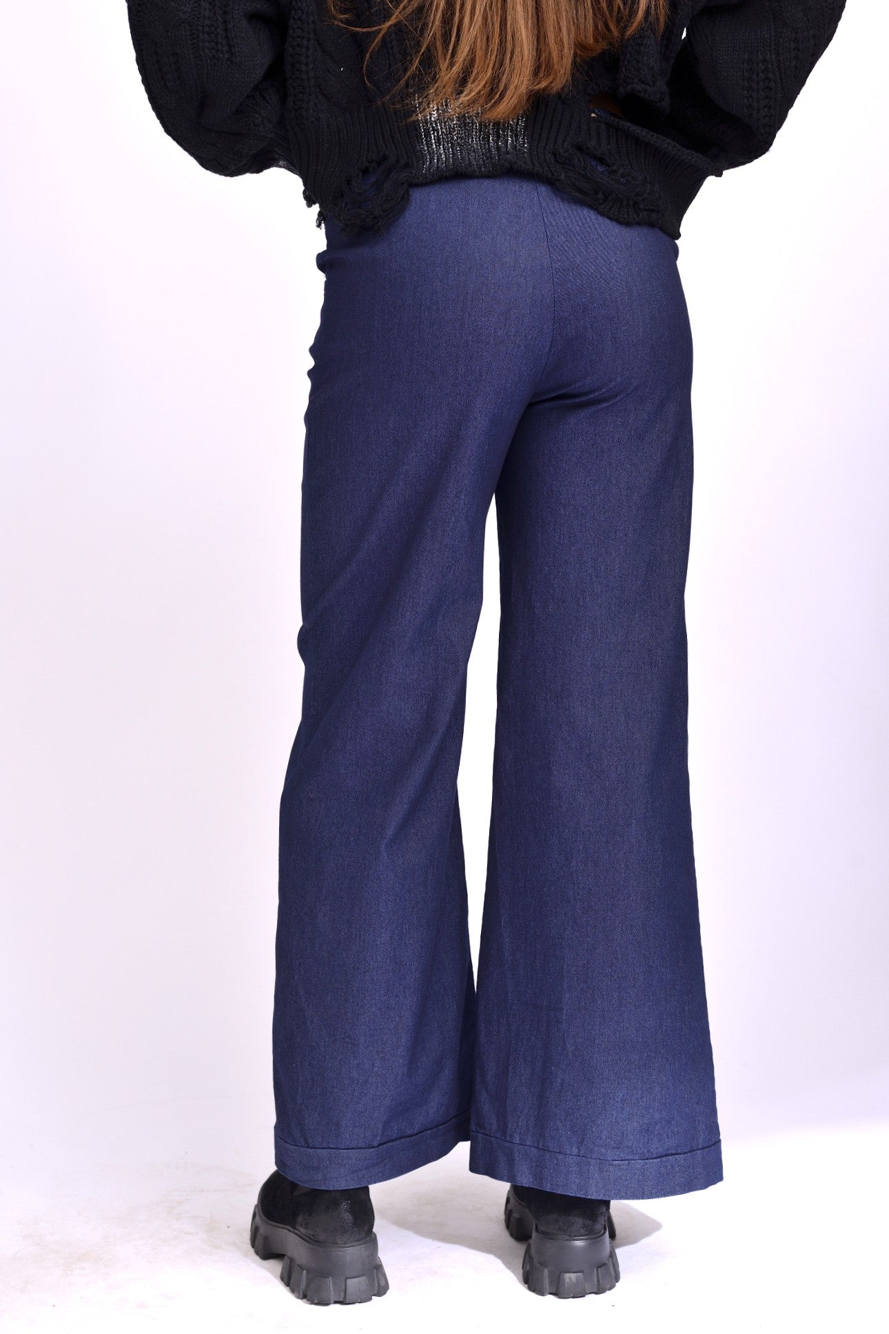 Detaliu de talie elastică cu cusături decorative pe blugi din denim bleumarin.