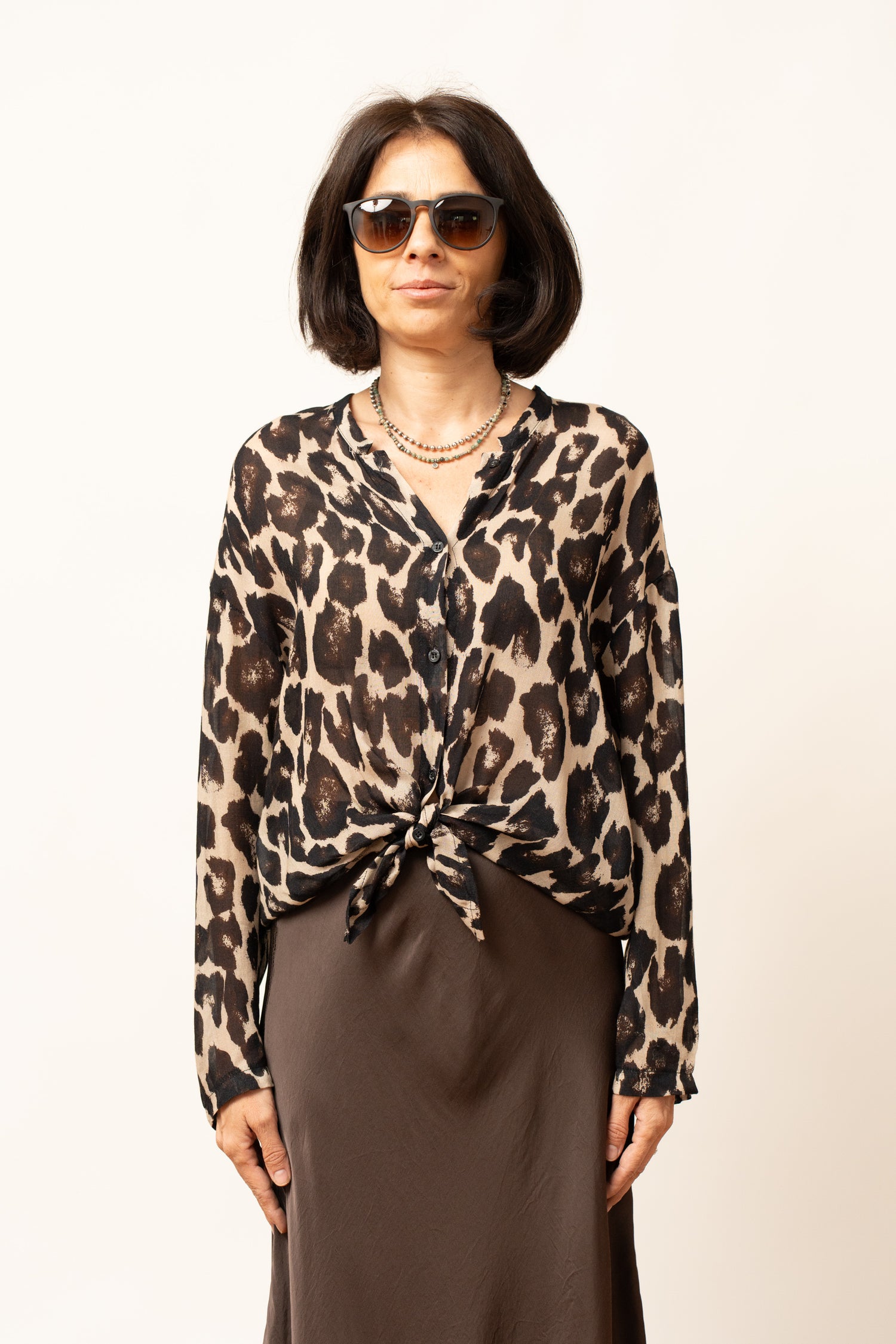 Bluza damă cu imprimeu animal print leopard, vedere din plan apropiat, detaliu nod frontal și guler în V.