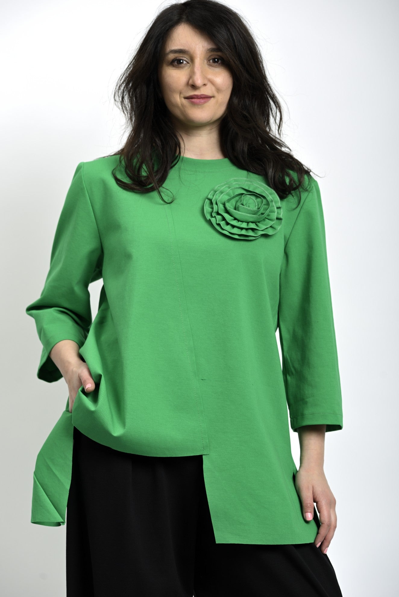 Bluză verde asimetrică, cu croială lejeră și detaliu floral aplicat pe partea frontală.