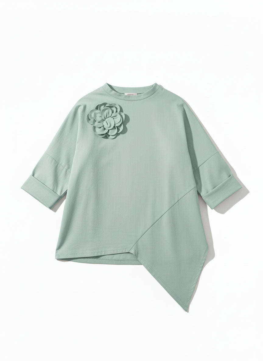 Bluză oversize verde pastel, cu croială amplă și tiv asimetric, fotografiată pe fundal neutru.