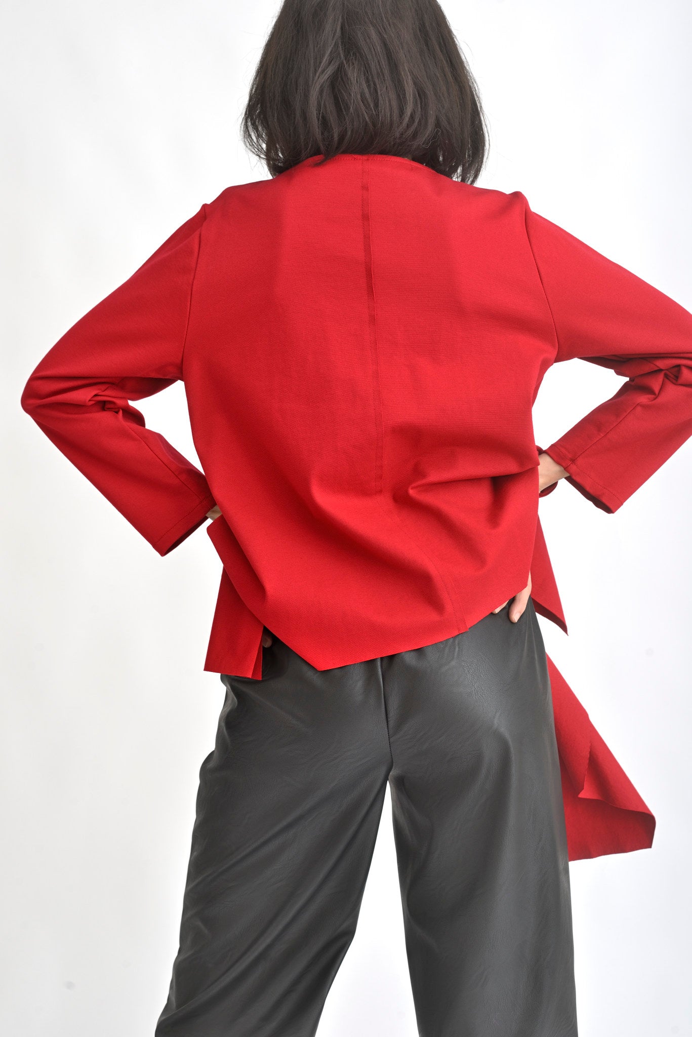 Vedere din spate a unei bluze roșii cu croială lejeră, mâneci lungi și finisaj elegant