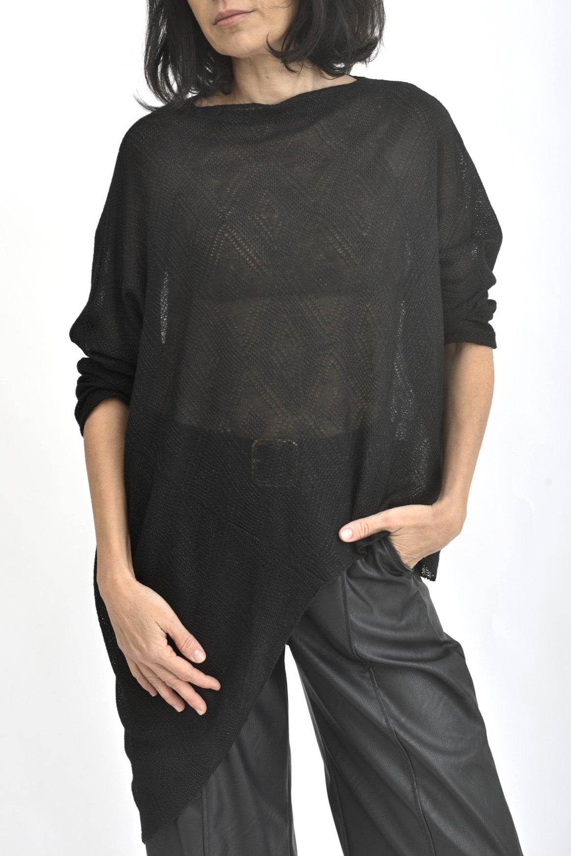 Detaliu textură semi-transparentă cu sclipici fin al unei bluze asimetrice negre